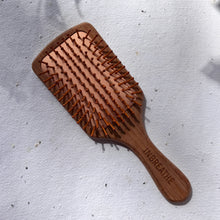 Load image into Gallery viewer, Eco-friendly wide bamboo paddle hairbrush with natural bristles for detangling and scalp massage