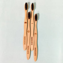 Load image into Gallery viewer, Natural wooden toothbrush designed with infused charcoal bristles for gentle daily care.