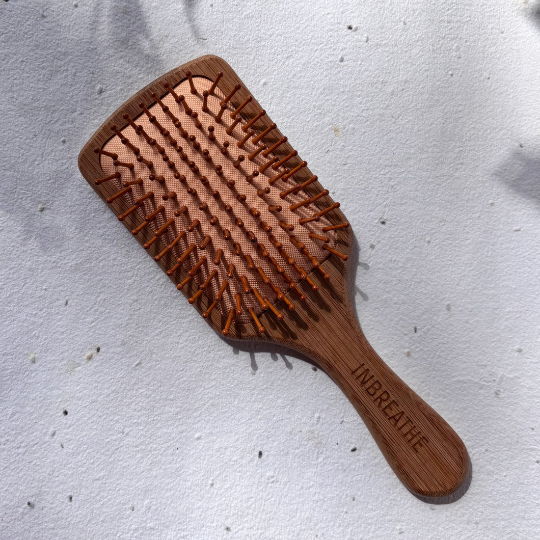 Eco-friendly wide bamboo paddle hairbrush with natural bristles for detangling and scalp massage