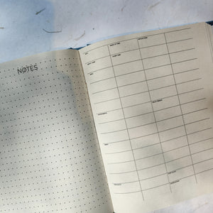 Close-up of recycled handmade paper used in undated planners, showing smooth texture and fine print.