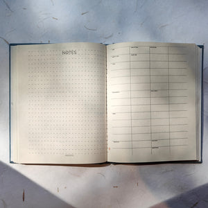 Open handmade paper daily planner with undated pages in green color for notes, tasks, and schedules