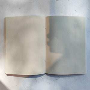 Open softcover blue notebook showing ruled pages on 120 GSM handmade paper