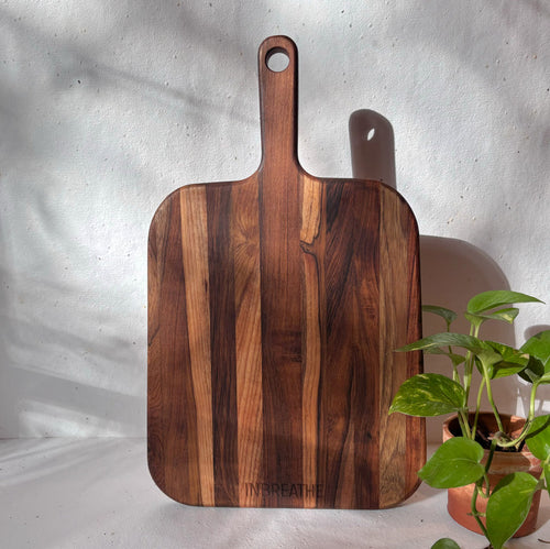 Top view of handcrafted teak wood chopping board with handle from InBreathe, ideal for kitchen use and vegetable cutting