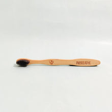 Load image into Gallery viewer, close-up of charcoal-infused bristles on bamboo toothbrush for antibacterial oral hygiene.
