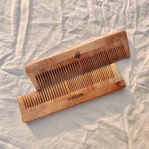 Natural wooden comb made from neem for scalp stimulation and reduced hair breakage.