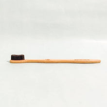Load image into Gallery viewer, Side profile of sustainable bamboo toothbrush handle made from antimicrobial bamboo wood.
