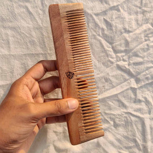 Handheld neem wood comb for dry or frizzy hair, helps maintain healthy strands.